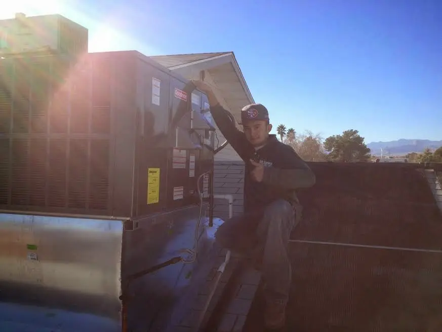 HVAC technician performing Air Duct Cleaning on a rooftop unit in Kinross
